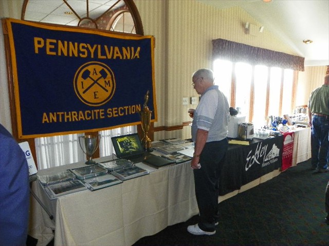 Members and guests look at exhibits of mining artifacts with items from the collections of John Podgurski, Reading Anthracite, Eckley Miners Village, the Scranton Anthracite Museum, F. Charles Petrillo, and Mike Korb; and a table publicizing the 2015 Field Conference of PA Geologists.